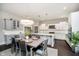 Bright dining area showcasing a stylish table set, elegant chandelier, and a seamless transition to the modern kitchen at 3989 Birkdale Dr, Carmel, IN 46033