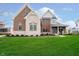 Charming two-story brick and stone home with a well-manicured lawn and inviting front porch at 3989 Birkdale Dr, Carmel, IN 46033