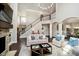 Elegant living room with a stone fireplace, staircase, and open layout at 3989 Birkdale Dr, Carmel, IN 46033