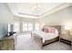 Spacious bedroom with plush carpet, tray ceiling, and large windows offering plenty of natural light at 3989 Birkdale Dr, Carmel, IN 46033