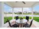 Back patio with a glass-top table and seating overlooking backyard pond views at 3989 Birkdale Dr, Carmel, IN 46033
