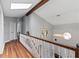 Upstairs hallway with hardwood floors, skylight and white railing at 4140 Melbourne Rd, Indianapolis, IN 46228