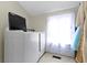 Laundry room features a new front load washer and dryer with a window and tile floors at 4140 Melbourne Rd, Indianapolis, IN 46228