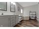 Bright bathroom featuring double vanity, soaking tub, and neutral tones, complemented by modern fixtures and stylish flooring at 4221 Millersville Rd, Indianapolis, IN 46205