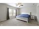 This bedroom features a ceiling fan, natural light, and neutral carpet at 4221 Millersville Rd, Indianapolis, IN 46205