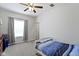 Cozy bedroom features ceiling fan, natural light, and neutral carpet at 4221 Millersville Rd, Indianapolis, IN 46205