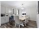 Open concept dining room with modern light fixture and flows into the kitchen at 4221 Millersville Rd, Indianapolis, IN 46205