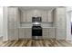 Elegant kitchen featuring gray cabinets, stainless steel appliances, and hardwood floors at 4221 Millersville Rd, Indianapolis, IN 46205
