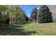 Spacious backyard with lush green grass and mature trees bordering the property at 452 Twin Oaks Dr, Carmel, IN 46032