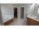 Bathroom featuring a large soaking tub, double vanity, walk in closet, and tiled floors at 452 Twin Oaks Dr, Carmel, IN 46032