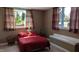 Cozy bedroom with a bright window and red furnishings offers a peaceful retreat at 452 Twin Oaks Dr, Carmel, IN 46032