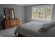 Bedroom with a white bed, a dresser with a mirror and a window providing natural light at 452 Twin Oaks Dr, Carmel, IN 46032