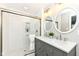 Modern bathroom featuring double sinks, stylish mirrors, a glass-enclosed shower, and neutral tones at 4625 Berkshire Ln, Indianapolis, IN 46226