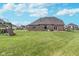 Spacious backyard with lush green lawn, brick house, patio, and play set, perfect for outdoor activities at 519 Southwind, Brownsburg, IN 46112