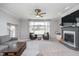 Spacious living room featuring a cozy fireplace, two leather chairs, and a large window at 519 Southwind, Brownsburg, IN 46112