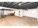 Finished basement featuring an open ceiling, light wood floors, built-in shelving, and comfortable seating area at 5849 Brouse Ave, Indianapolis, IN 46220