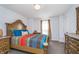 Bright bedroom with a large wood bed frame, complementary dressers, and soft, natural light streaming through the window at 6027 Brentwood Trce, Brownsburg, IN 46112