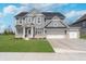 Charming two-story home boasts a three car garage and well-maintained front yard at 6027 Brentwood Trce, Brownsburg, IN 46112