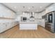 A kitchen features a large center island, stainless steel appliances, and wood flooring at 6027 Brentwood Trce, Brownsburg, IN 46112