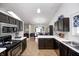 Open kitchen with dark cabinets, white countertops, flowing to a dining area at 6036 Maple Forge Cir, Indianapolis, IN 46254