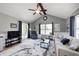 Vaulted living room featuring a ceiling fan, wainscoting, large windows and access to the backyard at 6036 Maple Forge Cir, Indianapolis, IN 46254