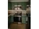 Updated kitchen showcasing stainless steel appliances, green cabinets, and white stone countertops at 6315 S Keystone Ave, Indianapolis, IN 46227