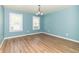 Bright bedroom featuring laminate wood floors, blue walls, white trim, and natural light at 7372 Deerfield Dr, Greenfield, IN 46140