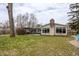 Back exterior view of home with a brick chimney and many windows at 7806 Meadowbrook Dr, Indianapolis, IN 46240