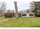 Back exterior view of home with a brick chimney and many windows at 7806 Meadowbrook Dr, Indianapolis, IN 46240