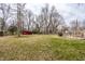 Expansive backyard with mature trees, a storage shed, and a fenced area for a garden or pets at 7806 Meadowbrook Dr, Indianapolis, IN 46240