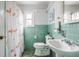 Retro bathroom with flamingo shower curtain, green tiles, and pedestal sink at 7806 Meadowbrook Dr, Indianapolis, IN 46240