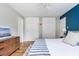 Bedroom featuring wood floors, blue accent wall, large wardrobes and a dresser with a picture at 7806 Meadowbrook Dr, Indianapolis, IN 46240