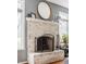 Close-up of a charming whitewashed brick fireplace with a decorative mirror and mantel decor at 7806 Meadowbrook Dr, Indianapolis, IN 46240