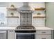 Close up of kitchen cooktop with subway tile backsplash and floating shelves at 7806 Meadowbrook Dr, Indianapolis, IN 46240