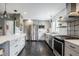 Well-lit kitchen featuring stainless steel appliances, gray cabinets, and tile flooring at 7806 Meadowbrook Dr, Indianapolis, IN 46240