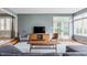 Well-lit living room with a contemporary TV console, stylish seating, and natural light from large windows at 7806 Meadowbrook Dr, Indianapolis, IN 46240