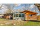 Back exterior with brick facade, patio, and sunroom, surrounded by mature trees at 7939 Sharon Dr, Avon, IN 46123