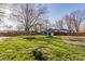 Large backyard featuring green grass, mature trees, storage sheds, and a trampoline at 7939 Sharon Dr, Avon, IN 46123