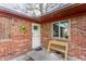 Inviting brick entryway featuring a bench, a storm door, and a decorative wreath on the front at 7939 Sharon Dr, Avon, IN 46123