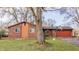 Charming brick home with a well-maintained lawn, a red garage door, and mature shade trees at 7939 Sharon Dr, Avon, IN 46123