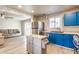 Open-concept kitchen featuring bright blue cabinets, stainless steel appliances, and modern flooring at 7939 Sharon Dr, Avon, IN 46123