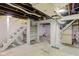 Unfinished basement with exposed ceiling, white-painted walls, staircase, and potential for customization at 805 N Tuxedo St, Indianapolis, IN 46201
