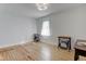 Bright bedroom with hardwood floors, a window letting in natural light, and vintage Singer sewing machine tables at 805 N Tuxedo St, Indianapolis, IN 46201