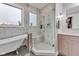 Bright bathroom featuring soaking tub under a window and a glass shower with marble tile at 8146 W 875 S, Pendleton, IN 46064