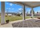 Spacious covered patio with decorative rug and a view of the beautiful backyard, garage, and long driveway at 8146 W 875 S, Pendleton, IN 46064