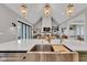 Kitchen island featuring a stainless steel sink, quartz countertops, and views of the living room at 8146 W 875 S, Pendleton, IN 46064
