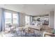 Open-concept living room featuring large windows, stylish furniture, and a view into the modern kitchen at 8710 Hollander Dr, Camby, IN 46113