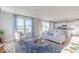 Bright living room with large windows, comfortable seating, and an open view into the modern kitchen at 8710 Hollander Dr, Camby, IN 46113