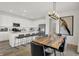 Open concept living with a modern kitchen, dining area with a wood table and stainless steel appliances at 8893 Alexander Ridge Dr, McCordsville, IN 46055