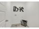 Bright laundry room with modern tile flooring, artistic wall decor, and a metal laundry basket at 8893 Alexander Ridge Dr, McCordsville, IN 46055